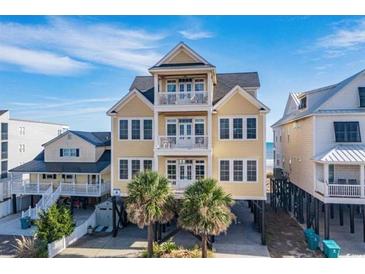 Beautiful beach house exterior; three stories, light yellow with dark roof at 132 N Waccamaw Dr., Murrells Inlet, SC 29576