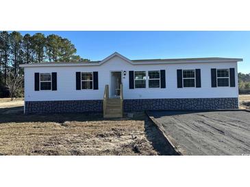 White single-story house with black shutters and stone base at 218 Eva Dr., Loris, SC 29569