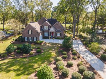 Brick home with landscaped yard and long driveway, seen from above at 1495 Hawthorn Dr., Pawleys Island, SC 29585