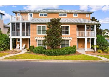 Two-story tan home with metal roof, balconies, and landscaping at 35 Lumbee Circle # 6, Pawleys Island, SC 29585