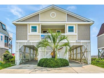 Two-story home with elevated parking and a palm tree at 551 S Waccamaw Dr., Garden City Beach, SC 29576