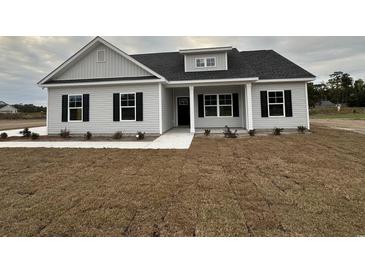 One-story home with gray siding, black windows, and front porch at 3854 Red Bluff Rd., Loris, SC 29569
