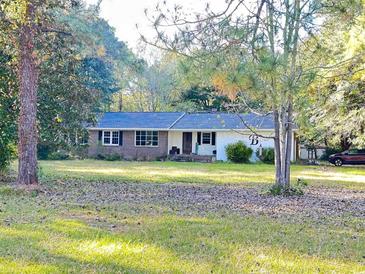 Ranch style home with brick and white siding, situated on a large lot at 1064 Heritage Rd., Loris, SC 29569