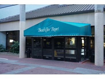 Welcoming entrance to Beach Cove Resort with teal awning at 4800 S Ocean Blvd. # 1522, North Myrtle Beach, SC 29582