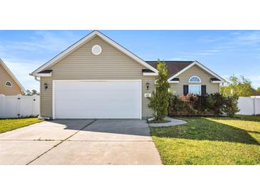 Tan house with a white garage door and manicured lawn at 481 Irees Way, Longs, SC 29568