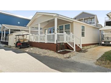 Cute beach cottage with white porch and golf cart at 6001 South Kings Hwy., Myrtle Beach, SC 29575