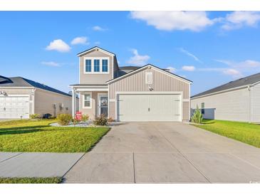 Two-story home with attached garage and landscaping at 1099 Saltgrass Way, Myrtle Beach, SC 29588