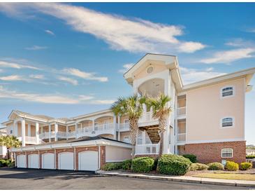 Exterior view of a peach-colored building with brick accents and garages at 4878 Dahlia Ct. # 24-304, Myrtle Beach, SC 29577