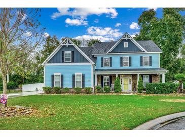 Two-story light blue house with stone accents and landscaping at 713 Shell Point Ct., Longs, SC 29568