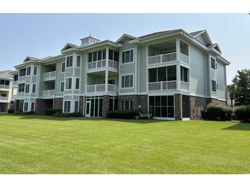 Green three-story building with balconies at 4893 Magnolia Pointe Ln. # 305, Myrtle Beach, SC 29577