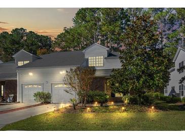 Brick townhouse with two-car garage and landscaped yard at night at 493 Shellbank Dr. # 2-B, Longs, SC 29568
