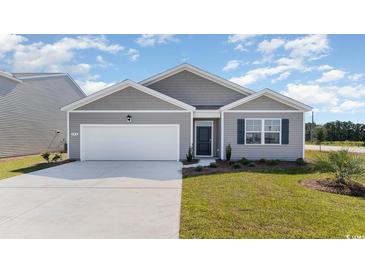 Gray siding, two-car garage, and landscaped lawn characterize this charming house at 7302 Meadow Walk Loop, Loris, SC 29569