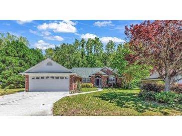 Brick ranch house with a two-car garage and landscaping at 4542 Mandi Ave., Little River, SC 29566