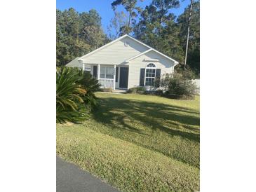 One story home with light beige vinyl siding, front porch, and well-manicured lawn at 9804 Conifer Ln., Murrells Inlet, SC 29576