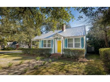 Charming light blue cottage with metal roof, landscaping, and yellow front door at 332 N Congdon St., Georgetown, SC 29440