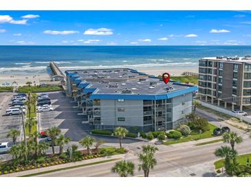 Aerial view of oceanfront condo building with parking and beach access at 6000 N Ocean Blvd. # 214, North Myrtle Beach, SC 29582