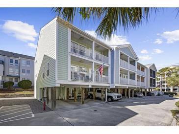 Two-story beach home with light green siding, balconies, and parking underneath at 209 North Hillside Dr. # 201, North Myrtle Beach, SC 29582