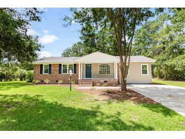 Newly renovated brick ranch home with a landscaped lawn and attached garage at 415 Apple Valley Rd., Loris, SC 29569