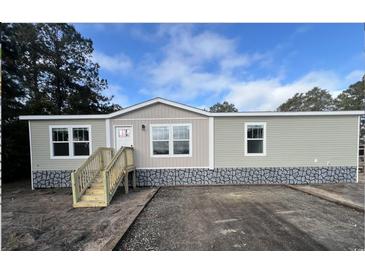 Attractive manufactured home with stone accents and a wooden staircase at 3641 Wayside Rd., Conway, SC 29527