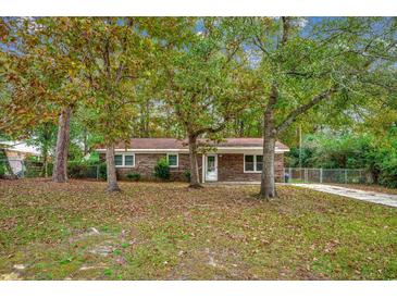 Brick ranch house with a large front yard and mature trees at 5630 Rosewood Dr., Myrtle Beach, SC 29588