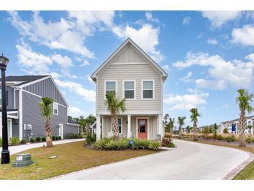 Tan two-story house with palm trees and a paved driveway at 9000 Mabel Ct., Longs, SC 29568