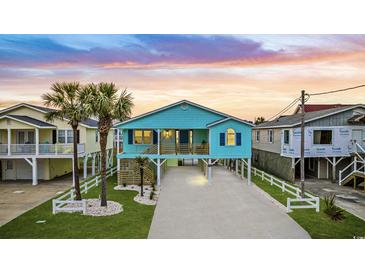 Charming teal beach house with white picket fence and spacious driveway at 6205 Nixon St., North Myrtle Beach, SC 29582