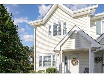Inviting two-story townhome with light yellow siding and a charming front porch at 101 S Barnwell St. # 38-A, North Myrtle Beach, SC 29582