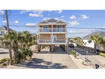 Two-story home with elevated foundation, balconies, and a spacious driveway at 1050 Waccamaw Dr., Garden City Beach, SC 29576