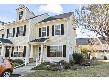 Two-story townhome with light beige vinyl siding, black shutters, and landscaping at 121 Barnacle Ln. # H -5, Little River, SC 29566