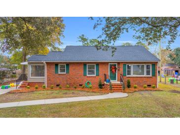 Brick ranch home with green door, landscaping, and a well-maintained lawn at 1768 Jasper St., Georgetown, SC 29440