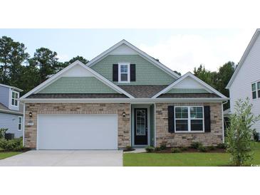 Two-story house with stone and shingle siding, a two-car garage, and landscaping at 6040 Forest Dell Ct, Myrtle Beach, SC 29579