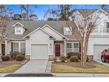 Attractive exterior of a two-story townhome with a garage and well-manicured landscaping at 230 Pilot House Pl. # 230, Carolina Shores, NC 28467