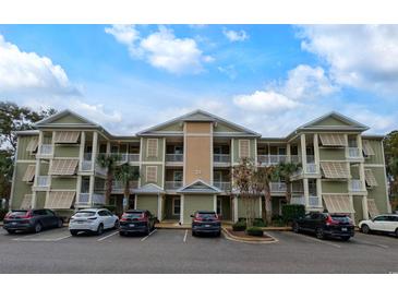 Two-story building with light green exterior, shutters, and ample parking at 34 Mingo Dr. # 1D, Pawleys Island, SC 29585