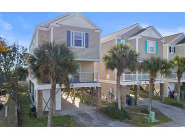 Charming beach house with palm trees and balconies at 411A Ocean Blvd. S, Surfside Beach, SC 29575