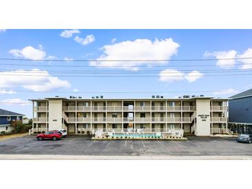 Exterior view of a multi-story condo building with a pool and parking lot at 4406 N Ocean Blvd. # C1, North Myrtle Beach, SC 29582