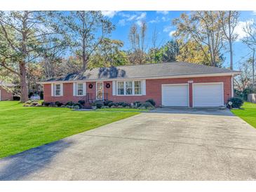 Charming red brick home with two-car garage and landscaped front yard at 5080 Forest Dr., Loris, SC 29569