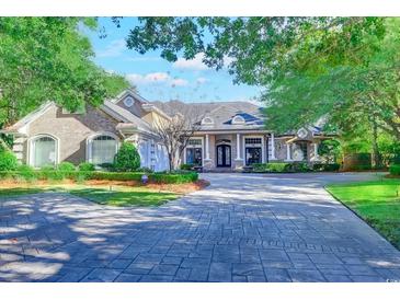 Elegant two-story home with brick and stone facade, paved driveway, and manicured landscaping at 604 Stableford Ct., Myrtle Beach, SC 29577