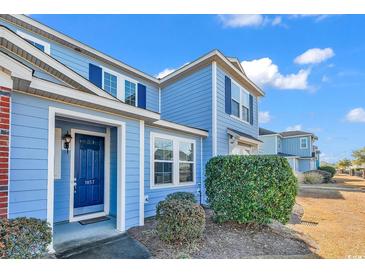 Two-story light blue townhome with navy blue front door and landscaping at 1857 Culbertson Ave. # 1857, Myrtle Beach, SC 29577