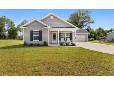 One-story home with gray siding, a covered porch, and a two-car garage at 612 Pine Oaks Farm Rd., Aynor, SC 29511