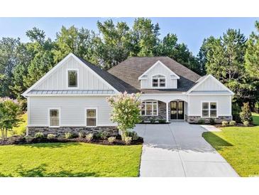 Craftsman style home with gray siding, stone accents, and a three-car garage at 1017 Muscovy Pl., Conway, SC 29526