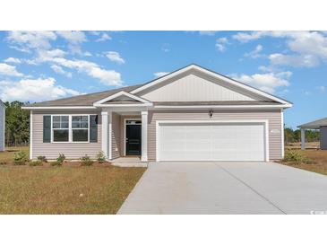 Two-story house with a light beige exterior, white garage door, and landscaping at 1477 Nokota Dr., Conway, SC 29526