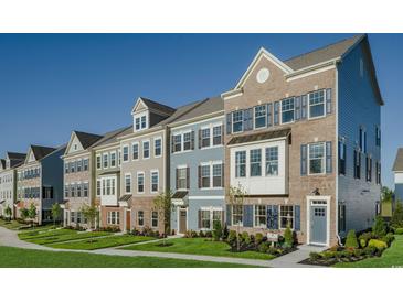 Row of charming three-story townhouses with brick and siding at 8476 Duke Pl. # 32, Myrtle Beach, SC 29572