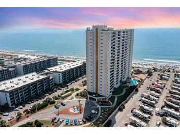 Aerial view of oceanfront high-rise building with parking and surrounding landscape at 5907 South Kings Hwy. # 308, Myrtle Beach, SC 29575