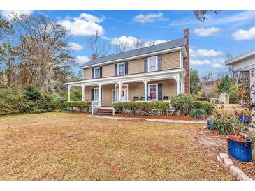 Two-story house with front porch, mature trees, and a spacious yard at 6011 Dick Pond Rd., Myrtle Beach, SC 29588