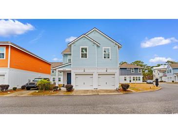 Two-story light blue house with a double garage and landscaping at 4739 Cloisters Ln., Myrtle Beach, SC 29577