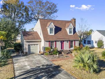 Cute house with a red door and attached garage, nicely landscaped at 702 Plantation Dr., Surfside Beach, SC 29575