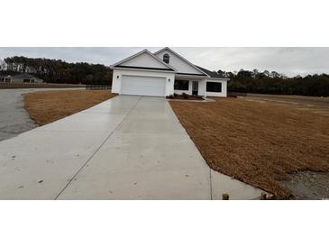 White house with a two-car garage and a long concrete driveway at Tbb 20 Privetts Rd., Conway, SC 29526