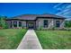 Brick home with gray siding, dark windows, and a walkway leading to the entrance at 209 Brush Ct., Little River, SC 29566