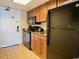 Compact kitchen with wood cabinets, black appliances, and granite countertops at 1105 S Ocean Blvd. # 940, Myrtle Beach, SC 29577