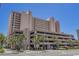 Exterior view of a large beachfront building, featuring ample parking and lush landscaping at 2207 S Ocean Blvd. # 1015, Myrtle Beach, SC 29577